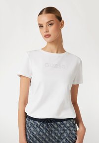 Guess MIT STRASSLOGO VORN - Marškinėliai su spaudiniu - weiß