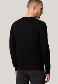 Czarny sweter, dzianinowa struktura, okrągły dekolt, długie rękawy, dopasowana talia, gładki design bez wzorów czy ozdób.