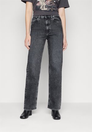 Υψηλής μέσης μαύρο τζην παντελόνι με ίσια γραμμή, με διακριτική φθορά και κλασικό σχέδιο πέντε τσεπών. Συνδυάζεται με ένα γραφικό μπλουζάκι.