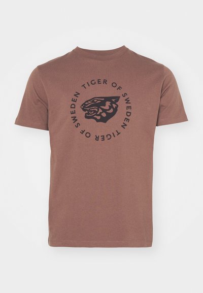 T-shirt en coton marron à manches courtes et col ras du cou. Présente un graphique circulaire noir d'une tête de tigre et le texte "TIGER OF SWEDEN."