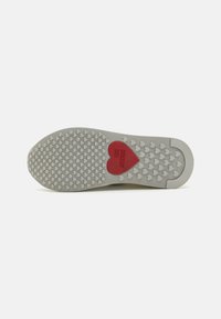 White sneaker sole with a textured pattern. Features a red heart with "LOVE MOSCHINO" embossed in the center.