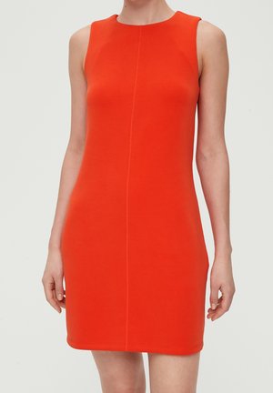 Vestido sin mangas, de longitud hasta la rodilla, de color naranja brillante con una costura vertical central, llevado por una persona sobre un fondo claro y sencillo.