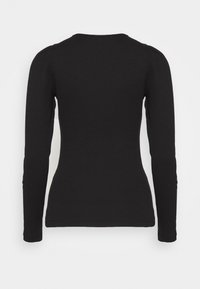Chemise noire à manches longues au design ajusté. Tissu doux et extensible avec un col rond et un léger bouffant aux coutures des épaules.