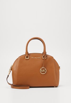 Borsa a mano in pelle marrone medio Michael Kors con doppi manici, tracolla removibile e ciondolo logo MK dorato appeso sul davanti.