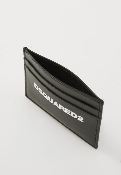 Black leather cardholder with three slots, featuring prominent white "DSQUARED2" logo. Smooth texture and streamlined design.