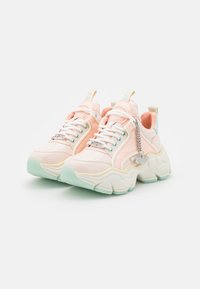 Sneaker chunky con tomaia in rosa lucido, dettagli in menta, suola bianca spessa e catena decorativa in argento sul lato.