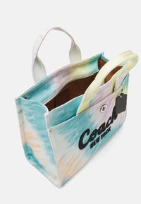 Sac fourre-tout en toile avec un motif tie-dye aux couleurs pastel. Logo noir « Coach New York », double anse et poche intérieure.
