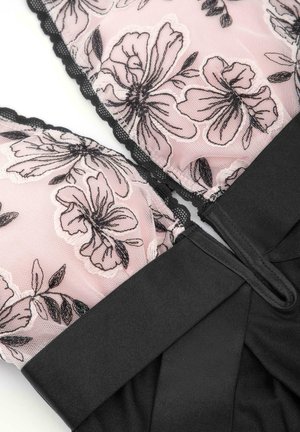 Czarny gorset z różową koronką w kwiaty, z falbaniastymi krawędziami i teksturowanym czarnym materiałem łączącym się na dole. Projekt zawiera detale na ramiączkach.