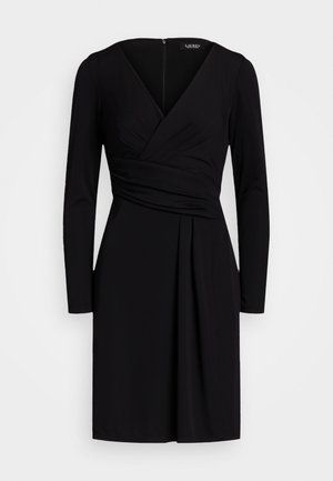 Robe noire à manches longues, longueur genou, avec encolure en V, détail plissé à la taille, et fermeture éclair dissimulée dans le dos, présentée sur fond blanc.