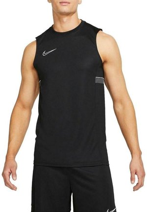 Homme portant un débardeur de sport noir et un short noir assorti avec des logos Nike blancs sur un fond blanc uni.