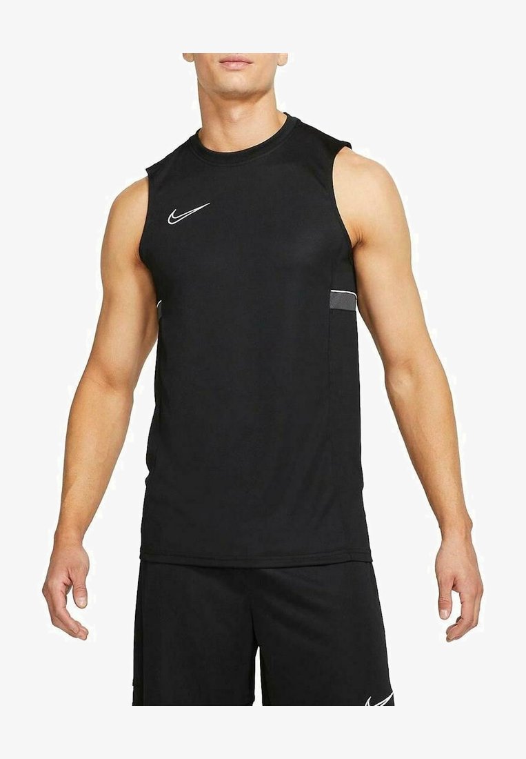 Homme portant un débardeur de sport noir et un short noir assorti avec des logos Nike blancs sur un fond blanc uni.