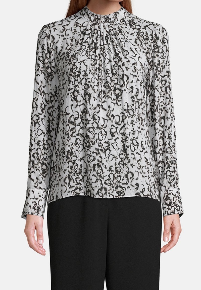 Long-sleeve blouse in light gray with a black abstract pattern, featuring a gathered neckline and cuffs. Soft fabric with a relaxed fit.