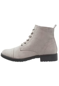 Stivale alla caviglia in suede grigio con punta arrotondata, design con sei occhielli per i lacci e suola in gomma nera textured. Presenta un piccolo inserto sul tallone.