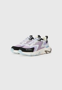 Purple and black sneakers with mesh upper, feature zigzag design, reflective laces, cushioned sole, and textured white and light blue outsole.