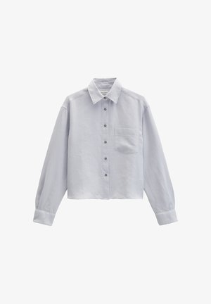 Chemise courte gris clair à manches longues avec boutons à l'avant, col pointu et poche poitrine unique sur fond blanc uni.