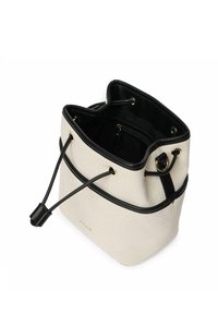 Bolso tipo cubo de lona en crema con detalles en cuero negro. Incluye herrajes dorados, cierre de cordón y un bolsillo con cremallera en el interior.