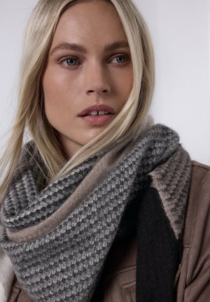 Écharpe en laine tricotée présentant un motif géométrique dans des nuances de gris et beige, avec une texture douce et un design superposé.