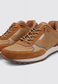 Zapatos deportivos marrones hechos de material sintético perforado y gamuza, con detalles en beige, cordones redondos y una suela resistente.
