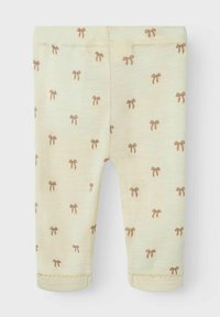 Leggings jaune clair en tissu doux, présentant un motif de nœuds marron répété, avec une ceinture côtelée et des ourlets cousus.