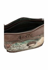Braune synthetische Tasche mit mehreren Reißverschlussfächern, auf einer Seite mit einem illustrierten Design und dem Text "Das Herz des Herzens der Erde."
