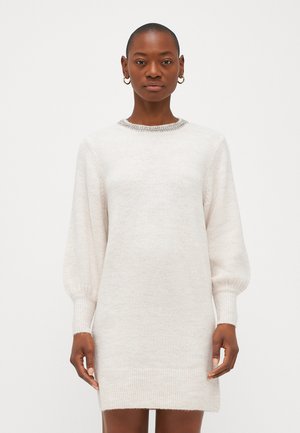 Lys beige strikket kjole med rund hals, lange puffermer, ribbede mansjetter og kant. Myk tekstur med subtile shimmerdetaljer.