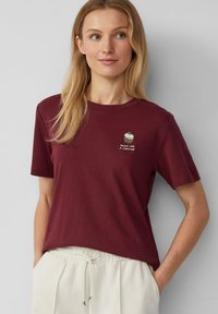 Bordeaux katoenen T-shirt met korte mouwen en ronde halslijn, met een cupcake-graphic en de tekst "SWEET LIKE A CUPCAKE" in het wit.