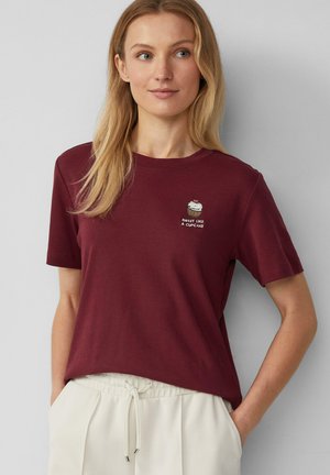Burgunderfarbendes Baumwoll-T-Shirt mit kurzen Ärmeln und rundem Halsausschnitt, versehen mit einem Cupcake-Graphic und dem Text "SÜSS WIE EIN CUPCAKE" in Weiß.