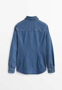 Chemise en denim bleu à manches longues vue de dos avec poignets boutonnés et col classique sur fond blanc uni.