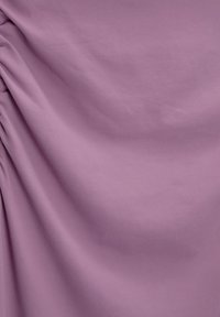 Tissu violet clair avec une texture lisse, présentant une drapée subtile et un détail froncé sur un côté, créant ainsi du volume et un mouvement.