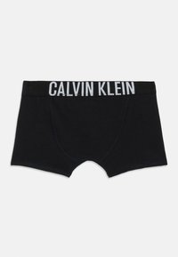 Črne moške bokserice z širokim pasom, na katerem je v krepki belini napis "CALVIN KLEIN".