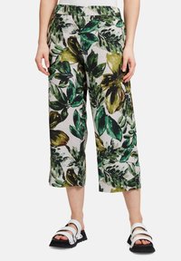 Zkrácené kalhoty vyrobené z lehkého materiálu s zelenožlutým květinovým vzorem na světlém pozadí. Mají elastický pás pro pohodlí.
