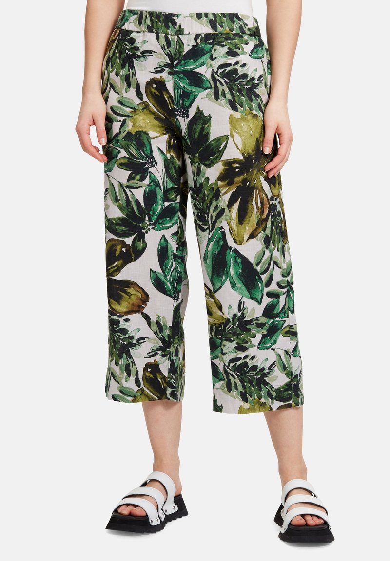 Zkrácené kalhoty vyrobené z lehkého materiálu s zelenožlutým květinovým vzorem na světlém pozadí. Mají elastický pás pro pohodlí.