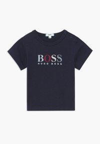 Námořnická modrá tričko s krátkým rukávem z jemn�é bavlny s kulatým výstřihem. Obsahuje vícebarevný text "BOSS" a "HUGO BOSS" v různých vzorech.