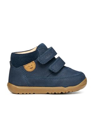 Chaussure pour tout-petit bleu marine avec deux bandes velcro, semelle en caoutchouc beige et patch beige avec visage souriant sur le côté.