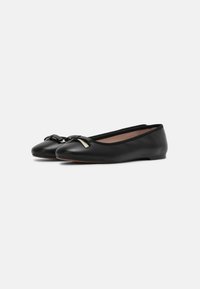 Bailarinas de cuero negro con puntera redondeada y un pequeño lazo decorativo en la parte delantera, que presentan un diseño minimalista y una suela delgada.