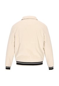 Beige corduroy jacket with a collar, ribbed cuffs, and a black striped waistband. The back features vertical ribbing texture.
