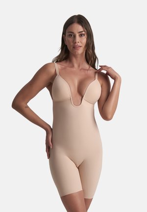 Naakt bodysuit met een diepe V-hals, verstelbare bandjes en een naadloos ontwerp. Korte beenuitsnijding en zacht, rekbaar materiaal voor comfort.
