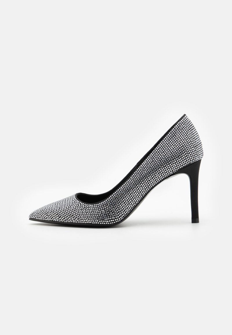 Escarpin noir à talon haut recouvert de strass argentés, avec un bout pointu et un talon aiguille fin sur fond blanc.