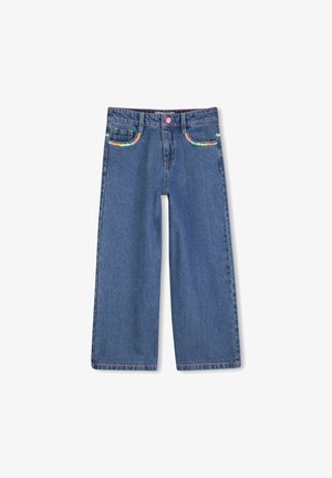 Közép kék színű, bőszárú farmernadrág, színes hímzett zsebekkel és rózsaszín gombbal. Sima textúra látható varrásokkal.