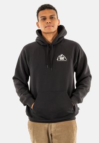 Sudadera negra con bolsillo tipo canguro, capucha con cordón y logo de montaña blanca. Fabricada con material suave, con puños y bajo acanalados.