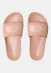Slide čības gaisā rozā sintētiskajā materiālā ar teksturētu apdari; platajām siksnām ir balts "The North Face" logotips. Līdzenas zoles.