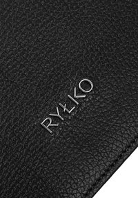 Pelle nera testurizzata con un logo argentato in rilievo "RYŁKO" in evidenza. Presenta un bordo cucito robusto e una superficie stampata.