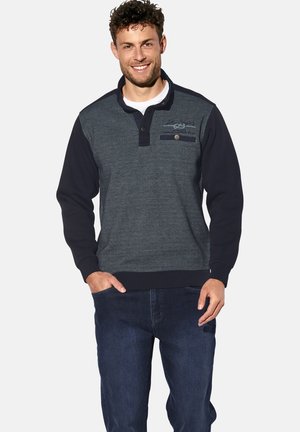 Dunkelblauer Pullover mit strukturiertem Obermaterial, langen Ärmeln und einem Knopfkragen. Verfügt über eine Brusttasche mit Klappe und kontrastierender Stoff.