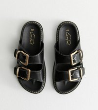 Sandali in pelle nera con due larghe cinghie, caratterizzati da dettagli con fibbie in oro. Cucitura lungo il bordo, suola piatta e design open-toe.