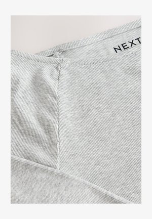 Lysegråt, ribbet stof med en glat tekstur. Har en sømdetalje og en mærkat med "NEXT" trykt i sort. Nærbillede.