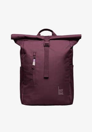 Sac à dos à rabat violet avec poche zippée à l'avant, sangle réglable avec boucle, poches latérales, poignée supérieure et logo "GOT BAG." en bas à droite sur le devant.