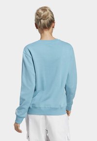 Ljusblå sweatshirt i mjukt material, med rundad halsringning, långa ärmar och ribbade muddar och nederkant. Subtil logotypdetalj på ärmen.