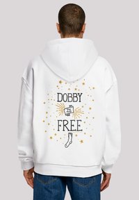 Biely mikina s veľkým grafikou na chrbte, ktorá hovorí "DOBBY JE SLADKÝ" v čiernej a zlatej farbe, obklopená zlatými hviezdami a ilustráciou ponožky.