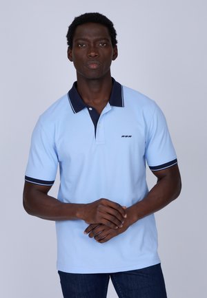 Polo bleu ciel avec un col bleu marine, doté d'une patte de boutonnage à deux boutons et de poignets rayés contrastés. Petit logo sur la poitrine, en matière coton.