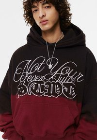 Čierna a vínová gradient mikina vyrobená z mäkkej látky, s bielym textom kombinovaným z kurzívy a tučného písma, s vreckom typu kengura.